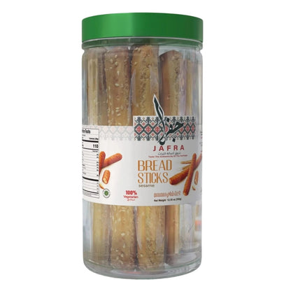 Jafra sesame breadsticks in clear glass jar with green lid, golden-brown crispy sticks with visible seeds and vegetarian label