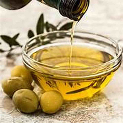Hana extra virgin olive oil pouring into glass bowl with green olives