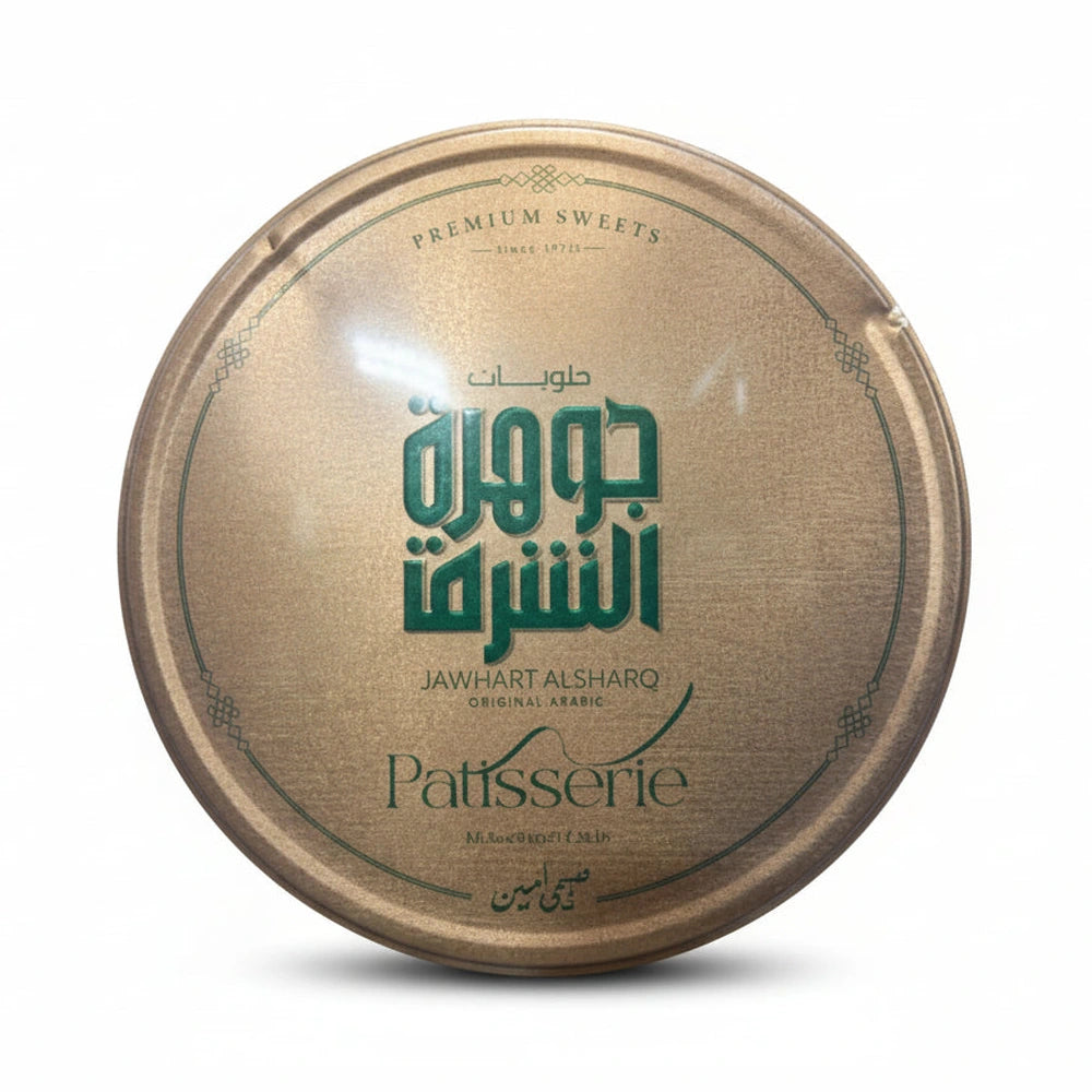 Jawhart Alsharq Greek Maamoul gold tin lid with green Arabic text and geometric border