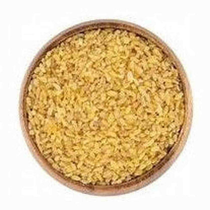 Close-up of golden-yellow finely cracked bulgur texture in wooden bowl