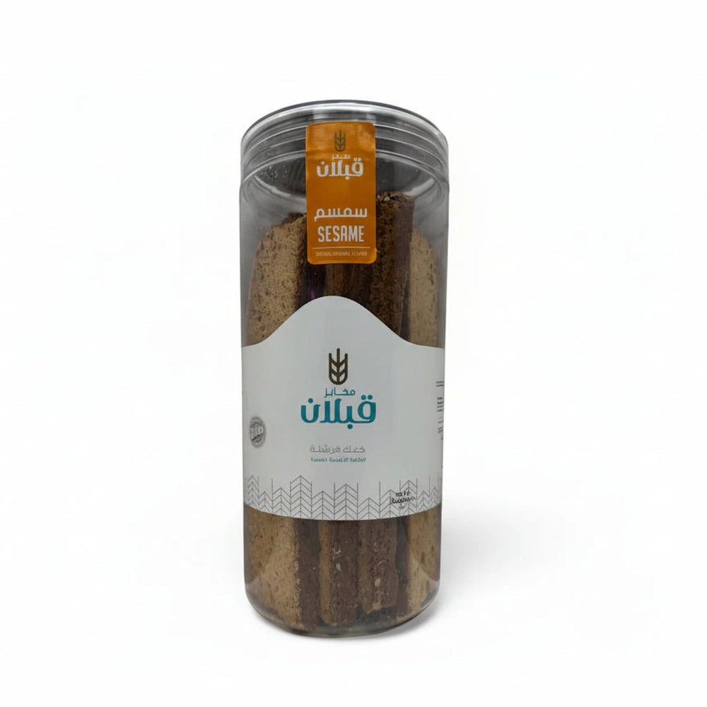 Qabalan Sesame Rusk in clear jar with orange label showing textured brown sticks and embedded white sesame seeds